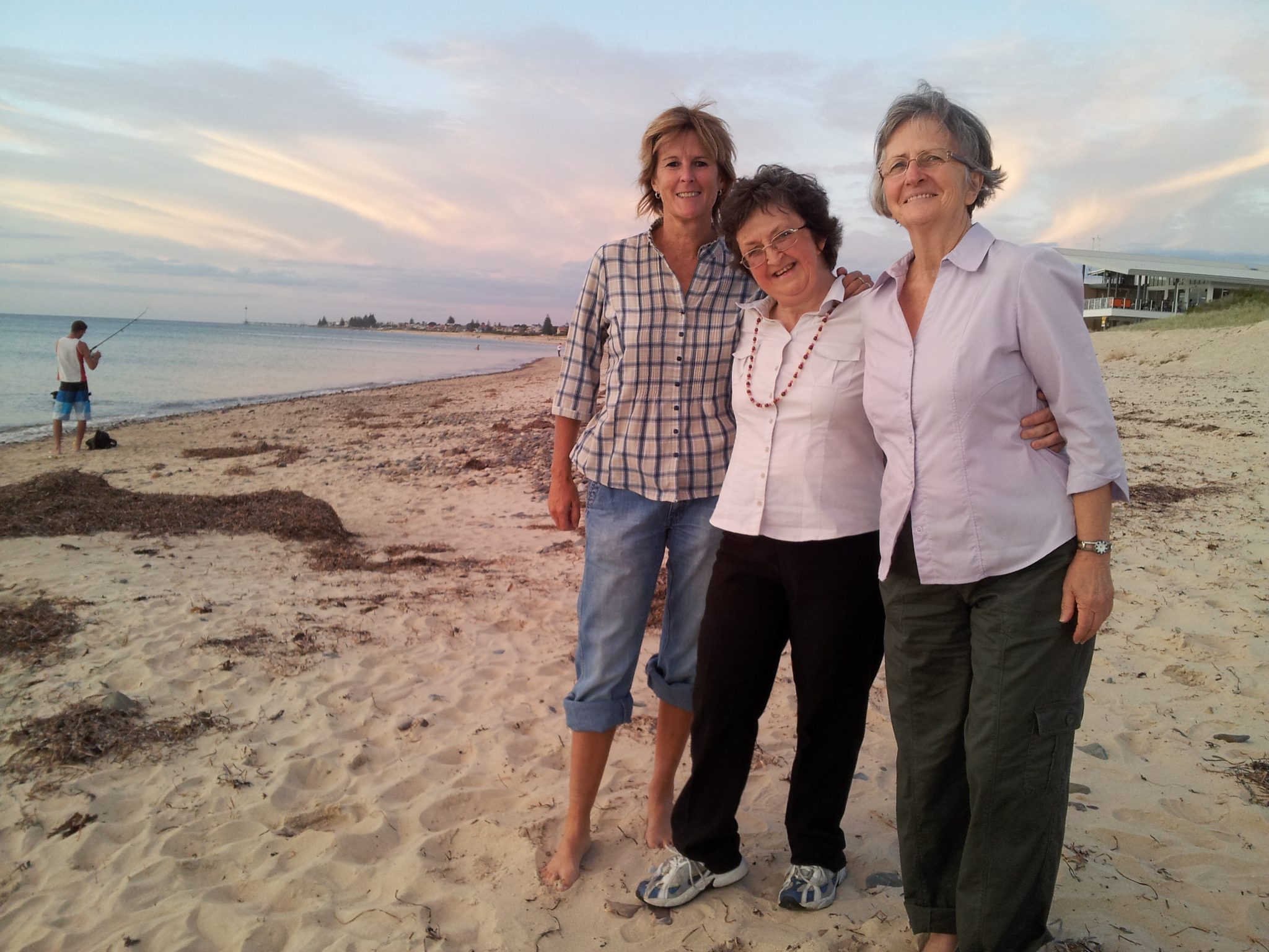 Beach sunset, 3 women standing on the sand