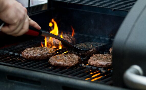 hamburgers cooking over an open grill